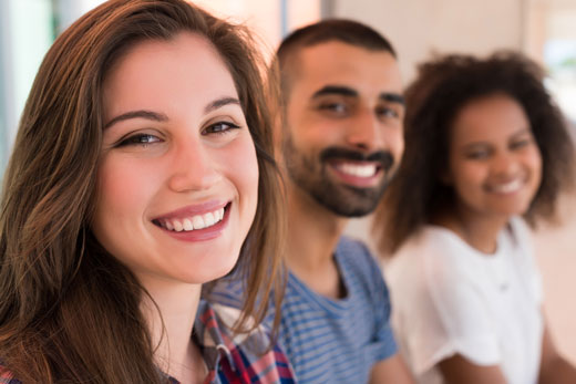 People smiling and showing perfect teeth after undergoing treatment with Invisalign