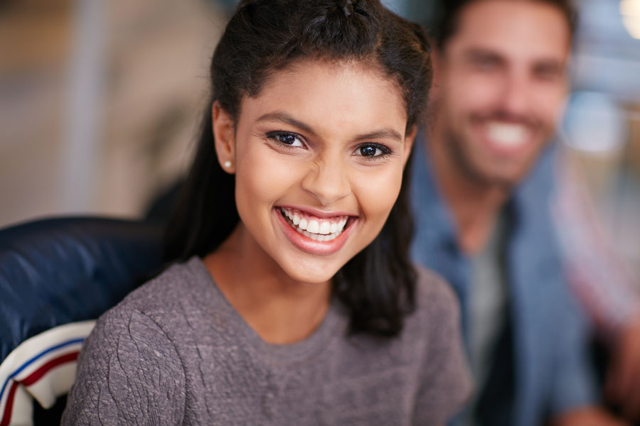Smiling woman looking at camera with Invisalign aligners in Chandler