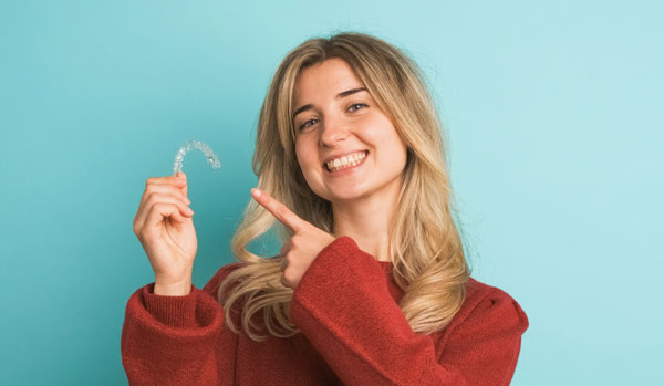 Teen showing an Invisalign aligner