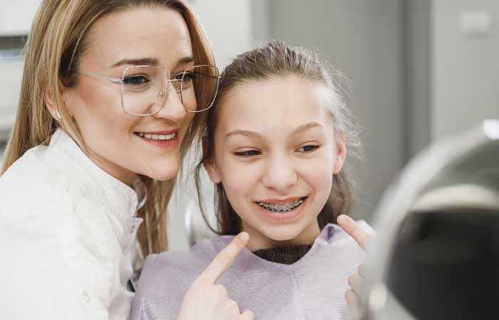 A picture of an orthodontist and a child wearing dental braces provided by Aspen Orthodontics in Gilbert, AZ